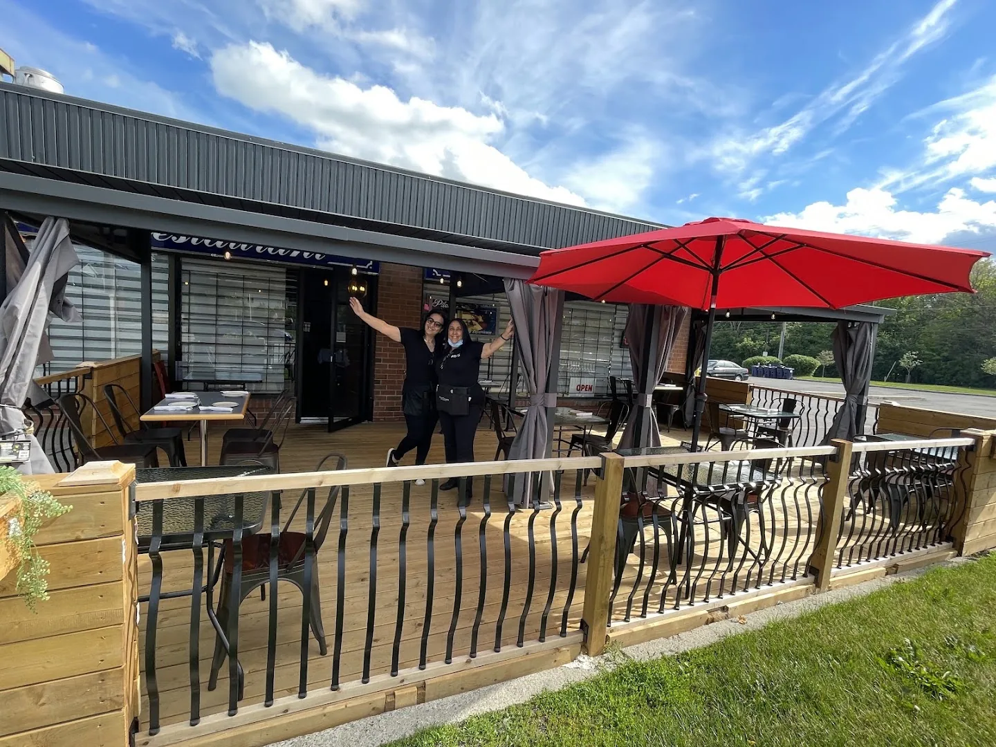 The patio out front, under the red umbrella, with the team waving hello